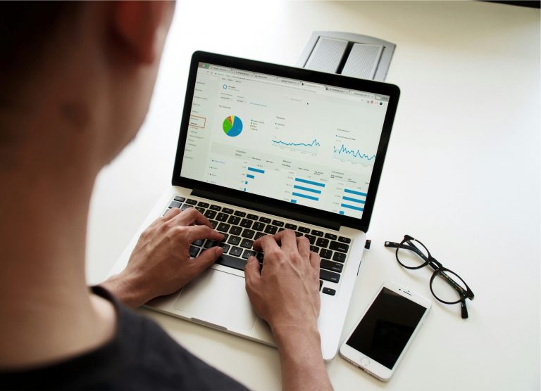 Freelance digital marketer from The Digi Dragon analysing SEO data results on Google Analytics at a modern office desk.